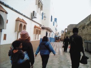 Sarah (carrying Felix), Ruby, and Anthony walking in the walled Medina of Assilah, Morroco